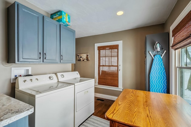 laundry area with cabinets, dark hardwood / wood-style floors, and washing machine and clothes dryer