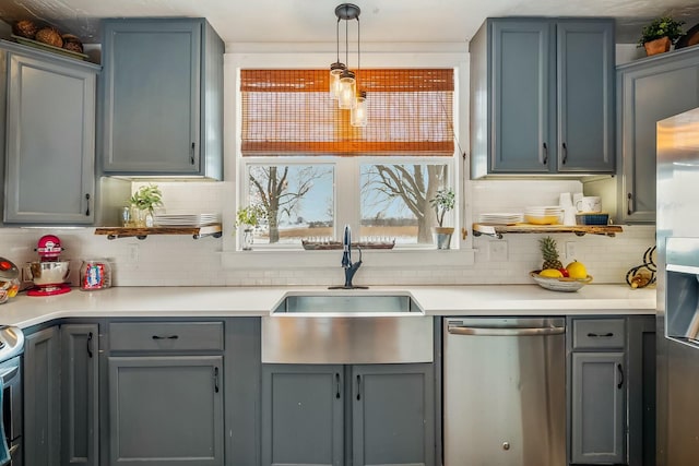 kitchen with backsplash, gray cabinetry, stainless steel appliances, sink, and pendant lighting