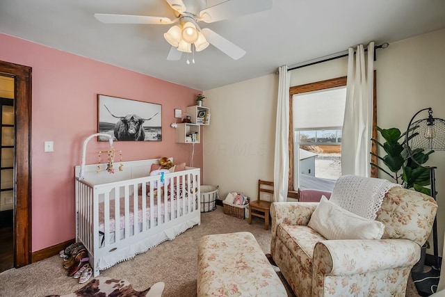 carpeted bedroom with a nursery area and ceiling fan