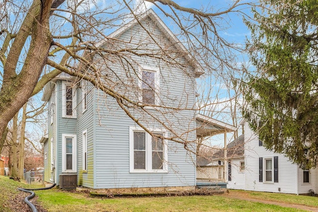 exterior space with central AC and a lawn