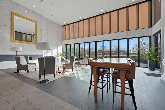 dining room featuring a towering ceiling and tile patterned floors