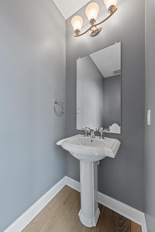 bathroom featuring baseboards, visible vents, and wood finished floors