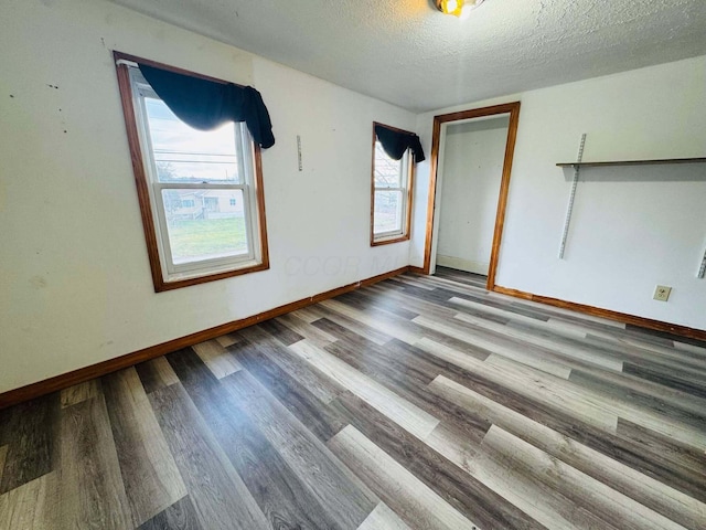 unfurnished room with a textured ceiling and hardwood / wood-style flooring