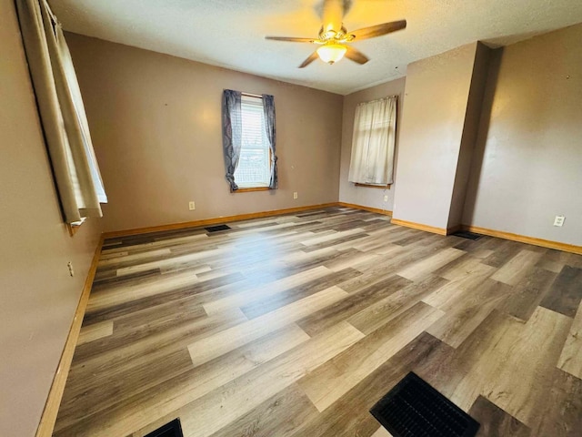 spare room featuring ceiling fan and light hardwood / wood-style flooring