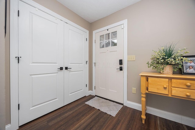 entrance foyer featuring a textured ceiling and dark wood-type flooring