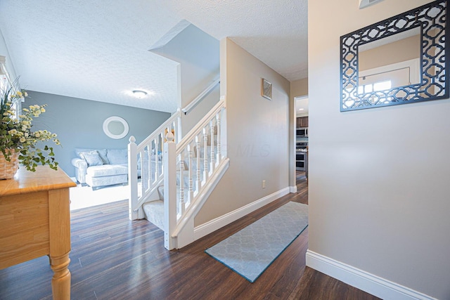 stairway with a textured ceiling and hardwood / wood-style flooring