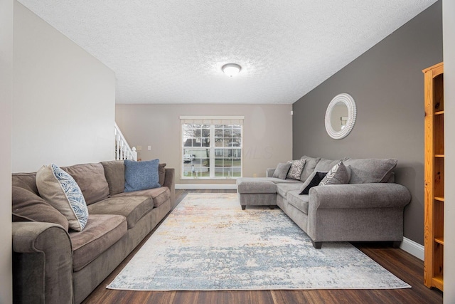 living room with a textured ceiling and dark wood-type flooring