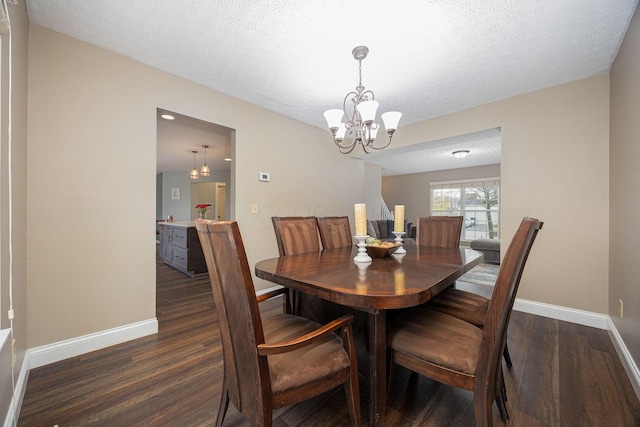 dining space featuring a textured ceiling, a notable chandelier, and dark wood-type flooring