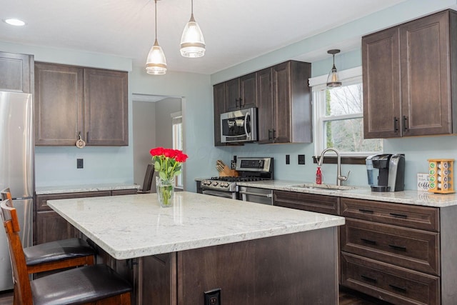 kitchen featuring dark brown cabinets, a kitchen island, sink, and appliances with stainless steel finishes