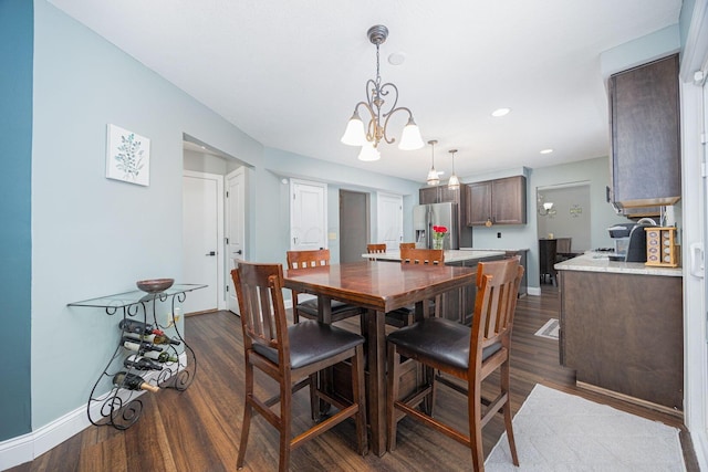 dining space with a chandelier and dark hardwood / wood-style flooring