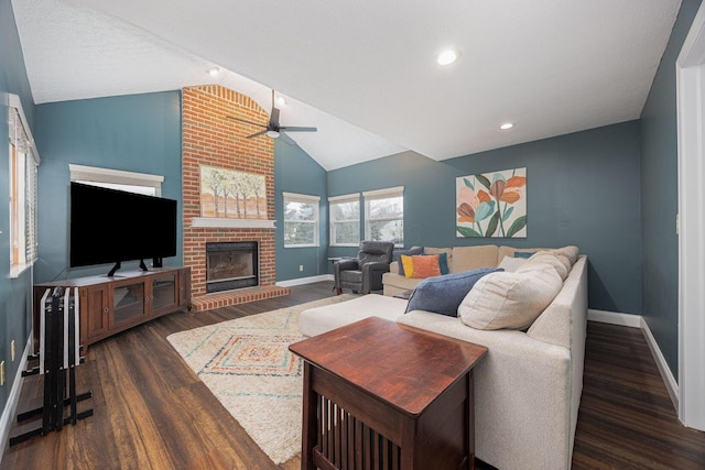 living room with a brick fireplace, a textured ceiling, ceiling fan, dark wood-type flooring, and lofted ceiling