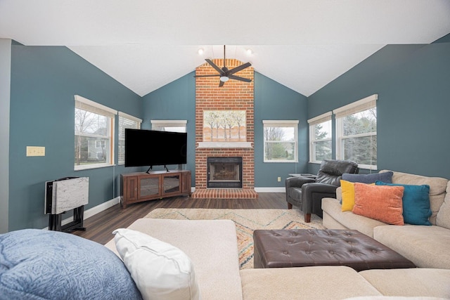 living room featuring a wealth of natural light, dark wood-type flooring, and a brick fireplace