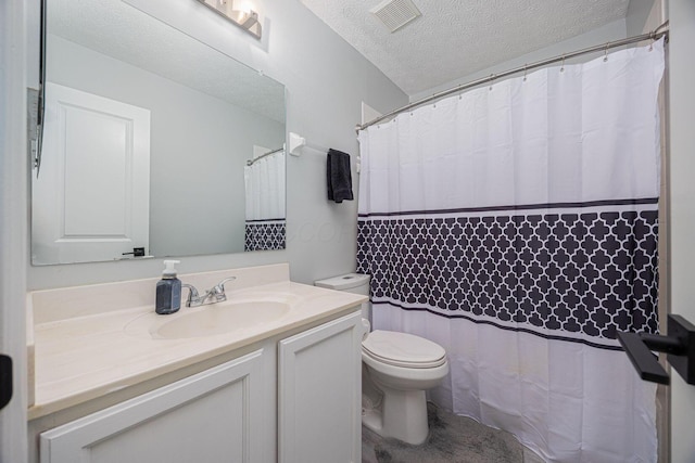 bathroom featuring vanity, toilet, and a textured ceiling