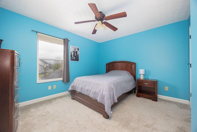 carpeted bedroom featuring ceiling fan and a textured ceiling