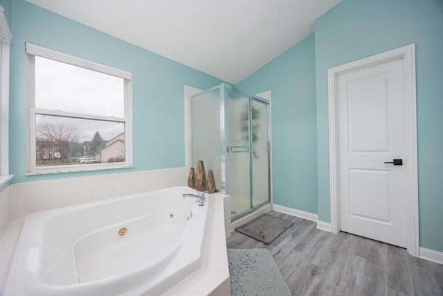 bathroom featuring plus walk in shower, hardwood / wood-style floors, a textured ceiling, and lofted ceiling