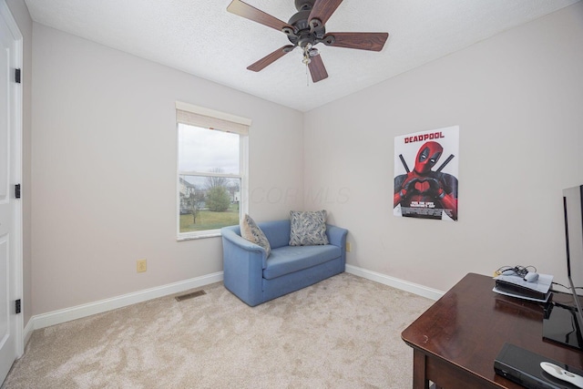 office featuring a textured ceiling, light colored carpet, and ceiling fan