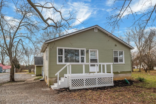 rear view of property featuring a deck