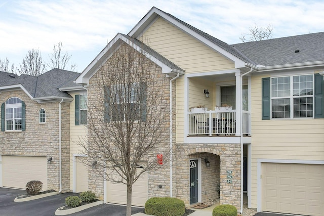 townhome / multi-family property featuring a balcony and a garage