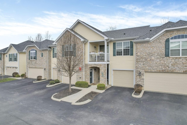 view of property with a balcony and a garage