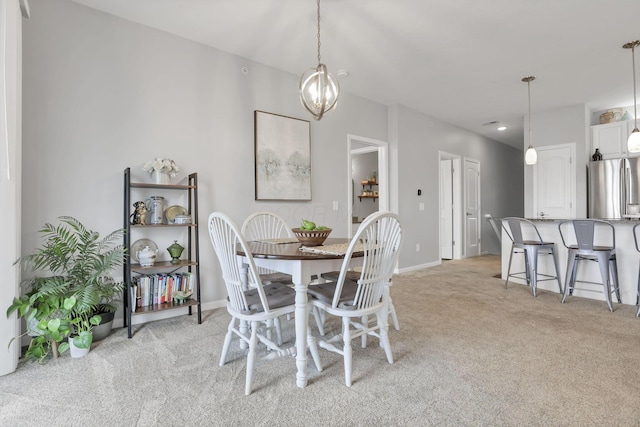 dining room with light colored carpet and a chandelier