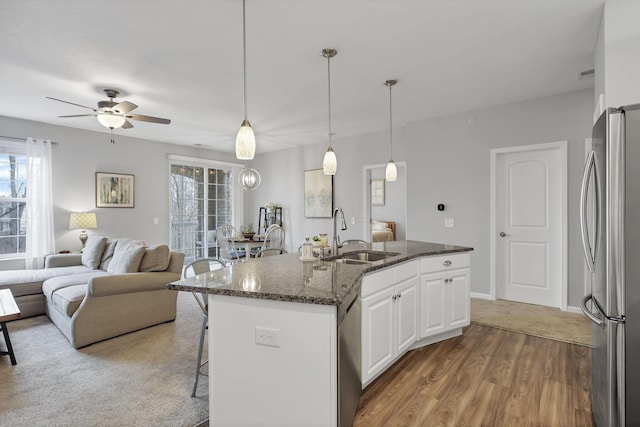 kitchen featuring appliances with stainless steel finishes, dark stone counters, ceiling fan, sink, and white cabinets