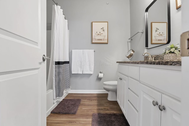 full bathroom featuring vanity, toilet, wood-type flooring, and shower / bath combo with shower curtain