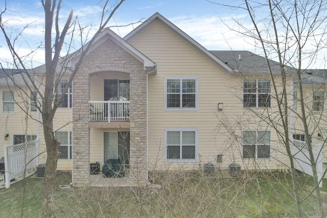 back of property featuring a balcony, central air condition unit, and a patio