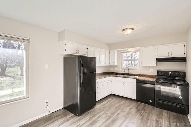 kitchen with white cabinetry, sink, black appliances, and light hardwood / wood-style flooring