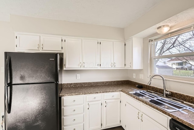 kitchen with black appliances, white cabinets, and sink