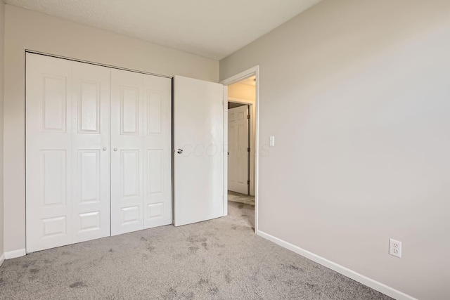 unfurnished bedroom with light carpet and a closet