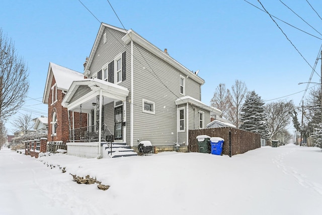 view of snowy exterior with covered porch