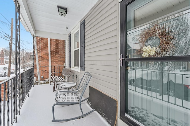 view of snow covered back of property