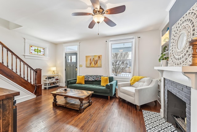 living room featuring dark wood-type flooring, ceiling fan, and a fireplace