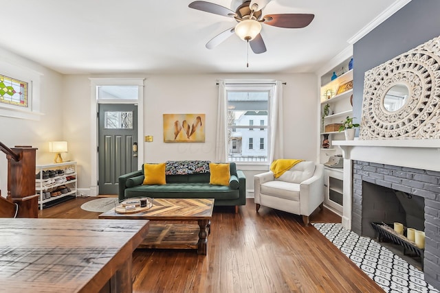 living room with ceiling fan, dark hardwood / wood-style floors, and a brick fireplace