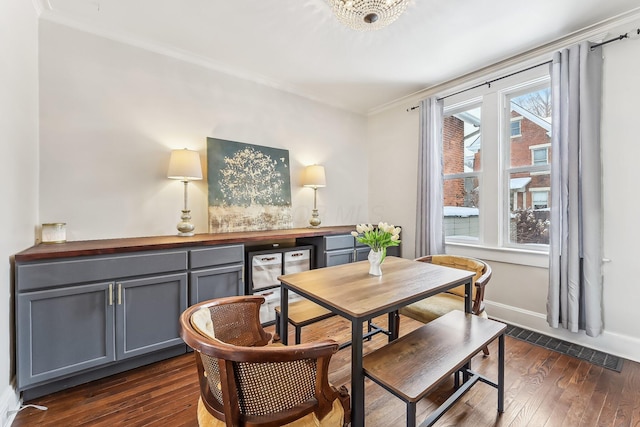 dining room featuring ornamental molding and dark wood-type flooring