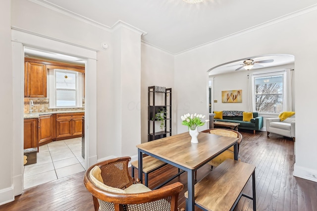 dining area with crown molding, a wealth of natural light, ceiling fan, and light hardwood / wood-style floors