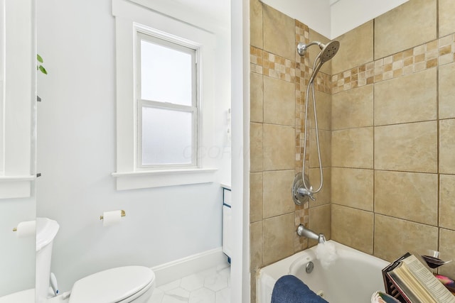 bathroom with tiled shower / bath and toilet