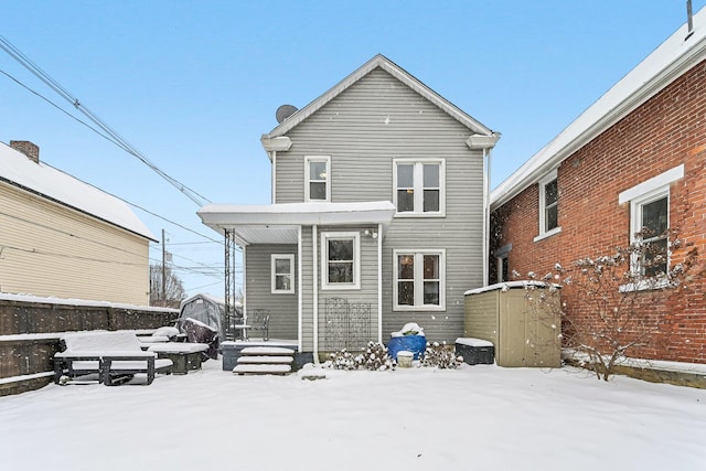 view of snow covered rear of property