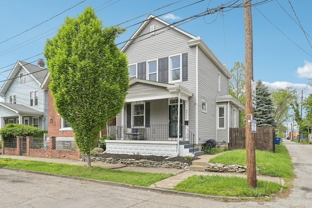 view of front facade with a porch and fence