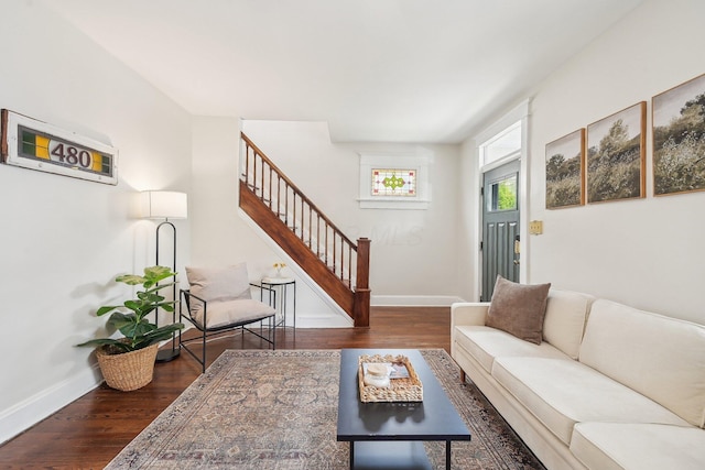 living area with baseboards, stairs, and wood finished floors