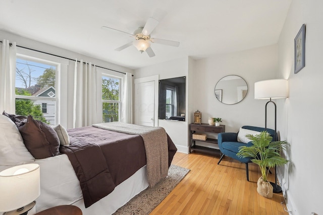 bedroom with light wood-type flooring, baseboards, and ceiling fan