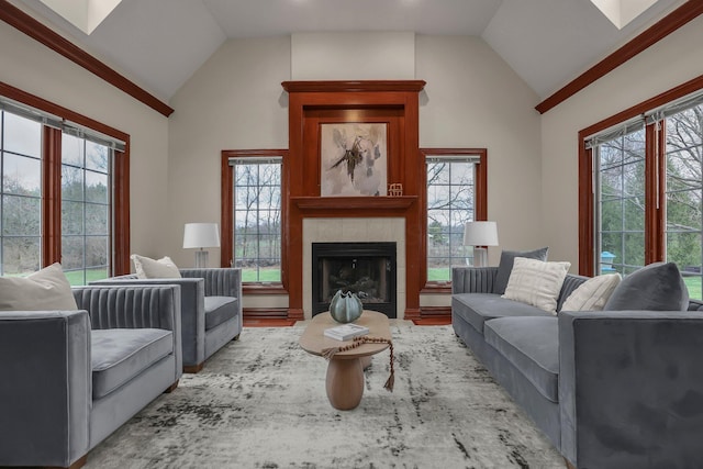 living room with light hardwood / wood-style floors, vaulted ceiling, and a tiled fireplace