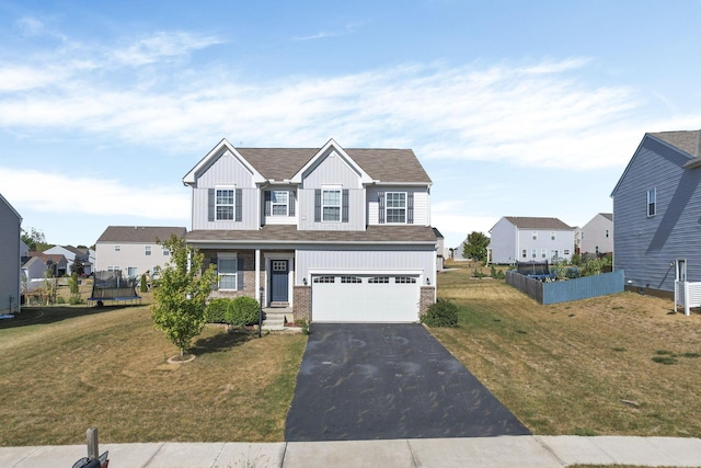 view of front of house with a trampoline, a front lawn, and a garage