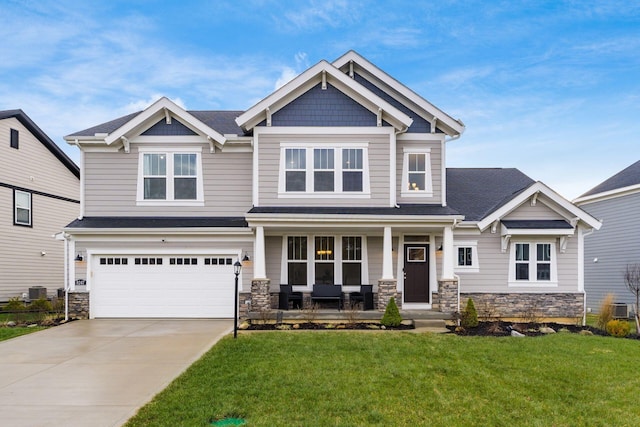 craftsman house with covered porch, cooling unit, a garage, and a front lawn