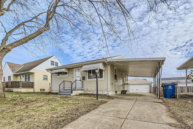 view of front of home featuring a carport, a garage, and an outbuilding