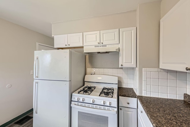 kitchen with white appliances, dark stone counters, white cabinets, and decorative backsplash