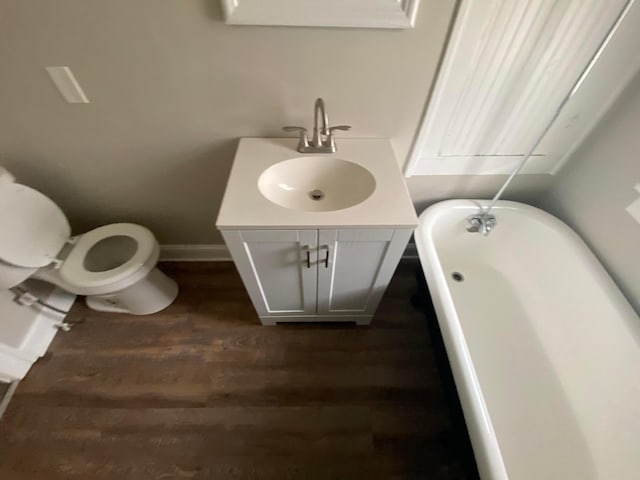 655-657 Frebis Ave, Columbus, OH 43206 - bathroom featuring a tub to relax in, toilet, vanity, and hardwood / wood-style flooring