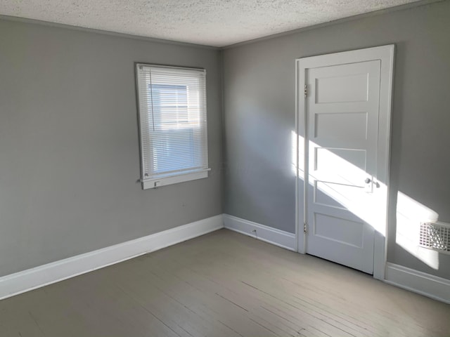 spare room with light hardwood / wood-style flooring and a textured ceiling