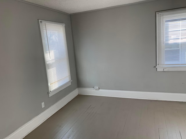 spare room featuring wood-type flooring and a textured ceiling