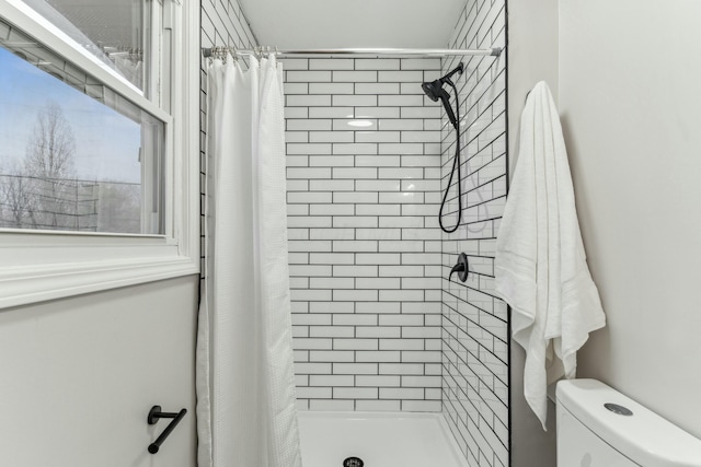 bathroom featuring curtained shower and toilet